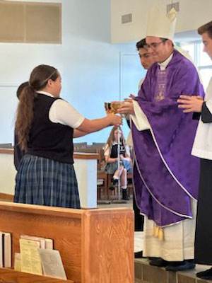 Pastor handing student a cup for sacrament