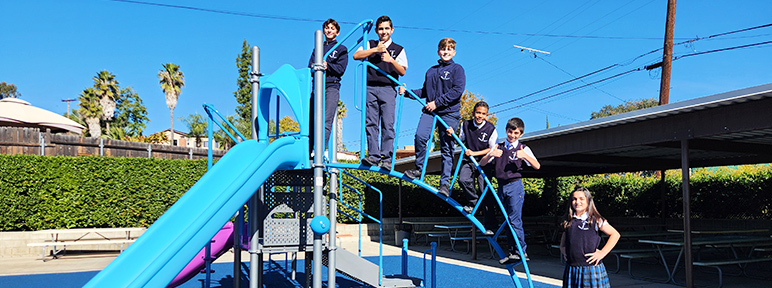 Students posing for a picture outside on the playground