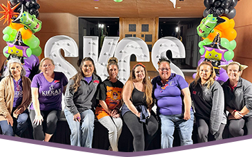 Parent and Teacher Group members sitting in front of SKCS letters